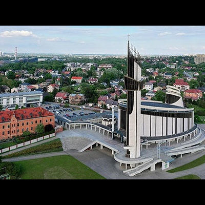 Igreja moderna branca com torre em área urbana vista aérea