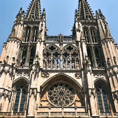 Fachada de catedral gótica com duas torres e vitrais contra céu azul