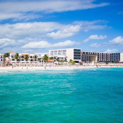 Hotel grande perto da praia com mar azul e céu nublado