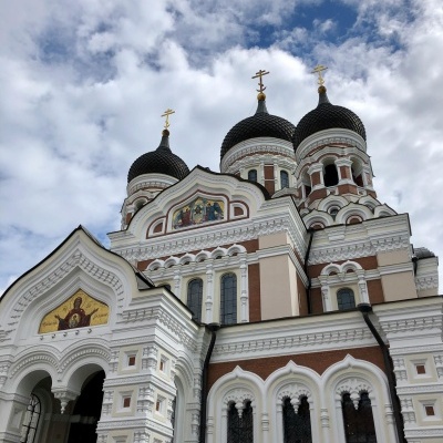 Igreja ortodoxa com cúpulas pretas e cruzes douradas sob céu nublado
