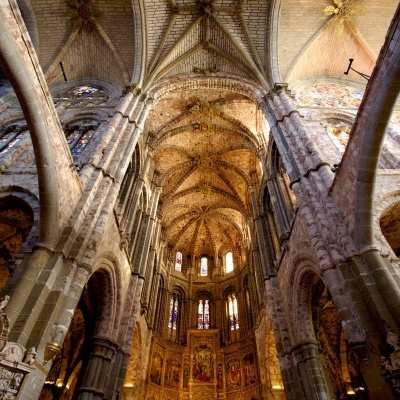 Interior da catedral gótica com arcos de pedra e vitrais