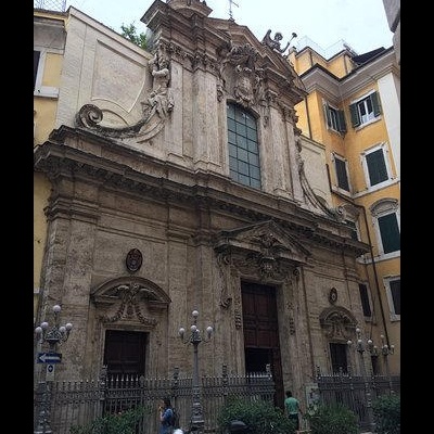 Fachada de igreja antiga de pedra entre edifícios residenciais