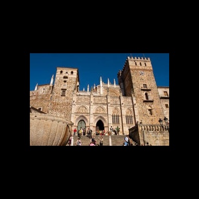 Fachada de catedral histórica em pedra com torres e escadaria e céu azul
