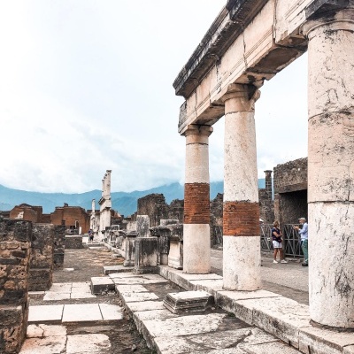 Ruínas arqueológicas com colunas cilíndricas de pedra e tijolo ao ar livre