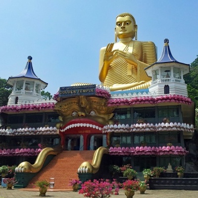 Templo dourado do Buda com estátua e escadaria vermelha em ambiente natural