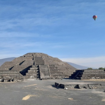 Pirâmide de pedra antiga com céu azul e balão de ar quente