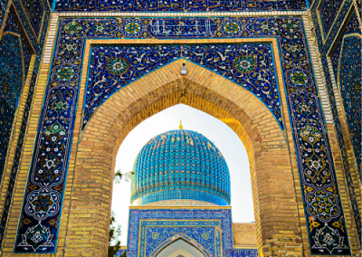 Cúpula azul decorativa vista através de um arco de tijolos amarelos com azulejos azuis