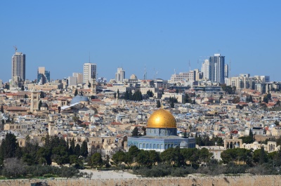 Cidade com cúpula dourada e edifícios ao fundo sob céu azul