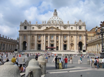 Edifício clássico com cúpula e colunas visto de uma praça com pessoas
