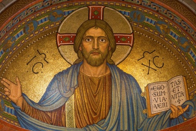 Mosaico de Jesus com túnica azul e livro com texto em latim