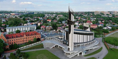 Igreja moderna branca com torre em área urbana vista aérea