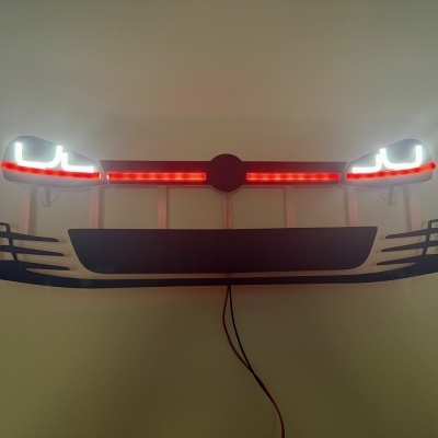 Frontal de carro decorativo iluminado com luzes LED brancas e vermelhas numa parede bege