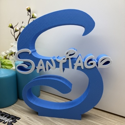 Objeto decorativo azul em forma de letra S com o nome Santiago em letras brancas e azuis