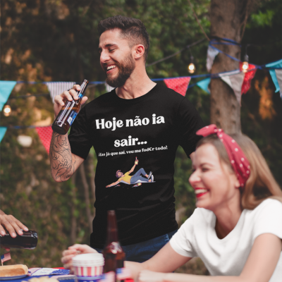 T-shirt preta com texto e ilustração usada por homem em festa ao ar livre.