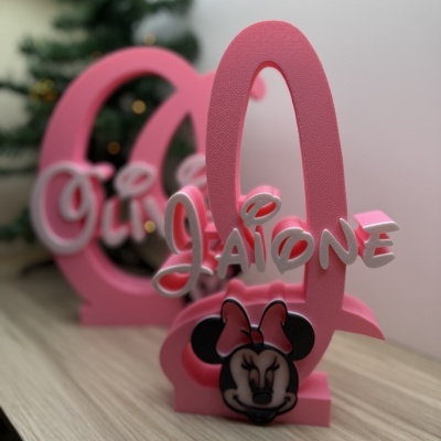 Nomes personalizados rosa e branco em espuma com Minnie Mouse e fundo desfocado.