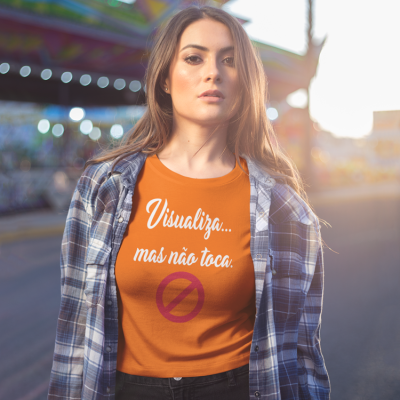 Mulher com t-shirt laranja curta e texto branco, junto a camisa xadrez azul e branca.
