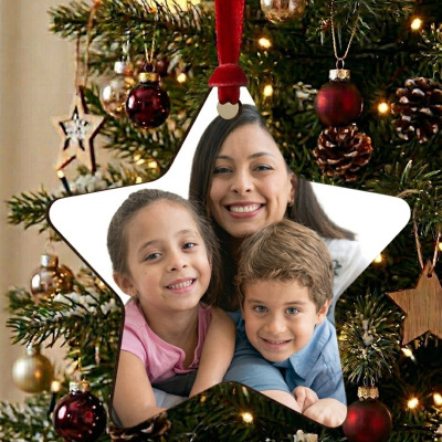 Enfeite estrela com fotografia pendurado na árvore de Natal decorada