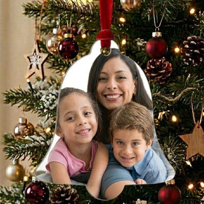 Enfeite de Natal em forma de sino com fotografia de família, pendurado numa árvore decorada