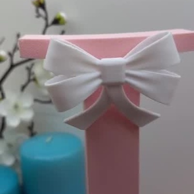 Moldura rosa em forma de L com nome Leonor em branco e ursinho decorativo
