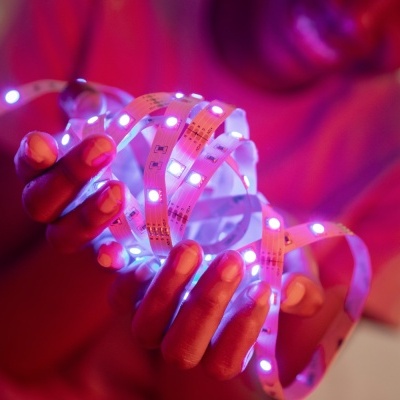 Fita LED azul brilhante num fundo vermelho e rosa