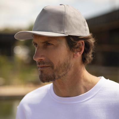 Homem a usar boné cinzento e t-shirt branca ao ar livre