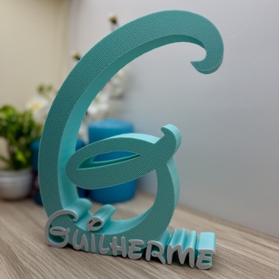 Objeto decorativo azul em forma da letra G com nome Guilherme