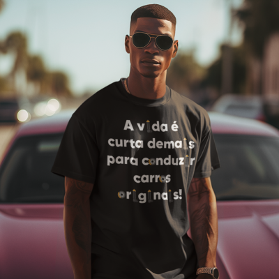 Homem com t-shirt preta com mensagem e óculos de sol, em rua com carro vermelho atrás