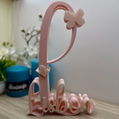 Objeto decorativo rosa com texto Lisbon e borboletas de veludo