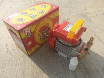 Bomba de água elétrica vermelha com caixa e garrafa plástica