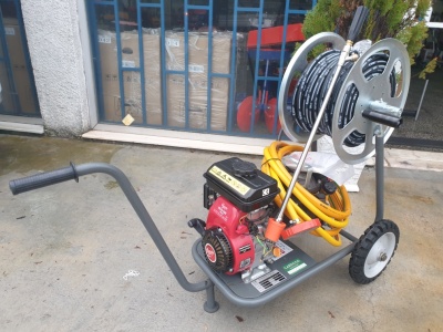 Máquina lavadora de alta pressão com motor vermelho e preto e carrinho metálico.