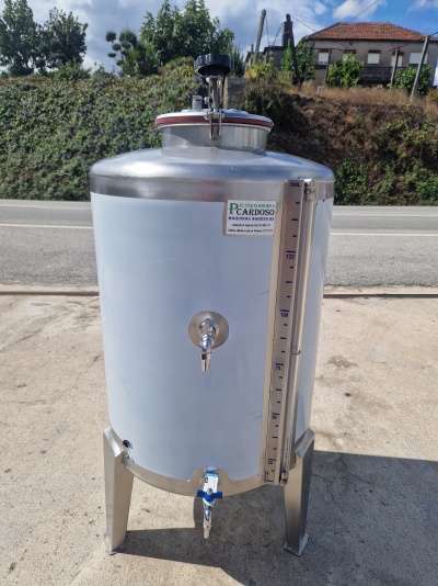 depósito cilíndrico de aço inoxidável branco com torneiras e escala transparente ao ar livre