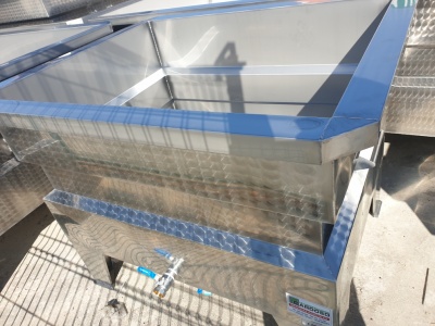 Tanque metálico industrial com torneira azul e textura quadriculada