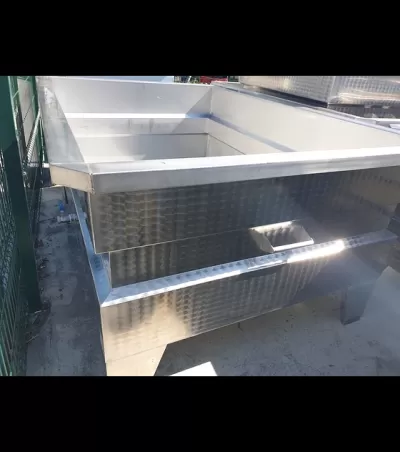 Tanque industrial retangular em inox prateado com acabamento texturizado ao ar livre