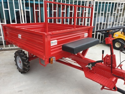 Carro agrícola vermelho com assento preto e rodas de pneus grossos