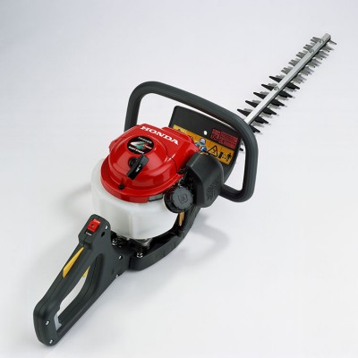 Cortasetos a gasolina com motor vermelho, depósito branco e lâmina metálica