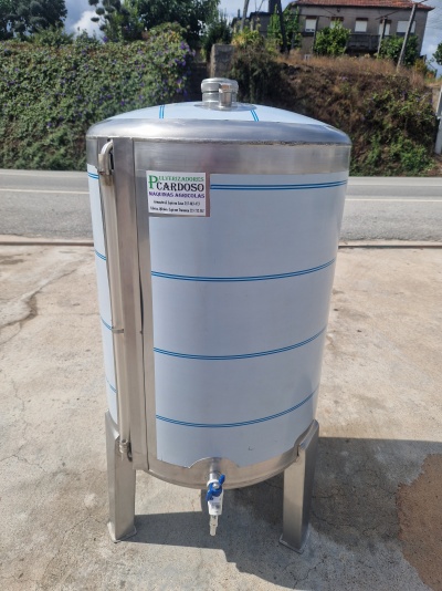 Cuba de inox branca com riscas azuis e torneira, em pavimento exterior junto a estrada.