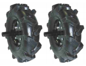 Dois pneus pretos de borracha com piso profundo para equipamentos agrícolas