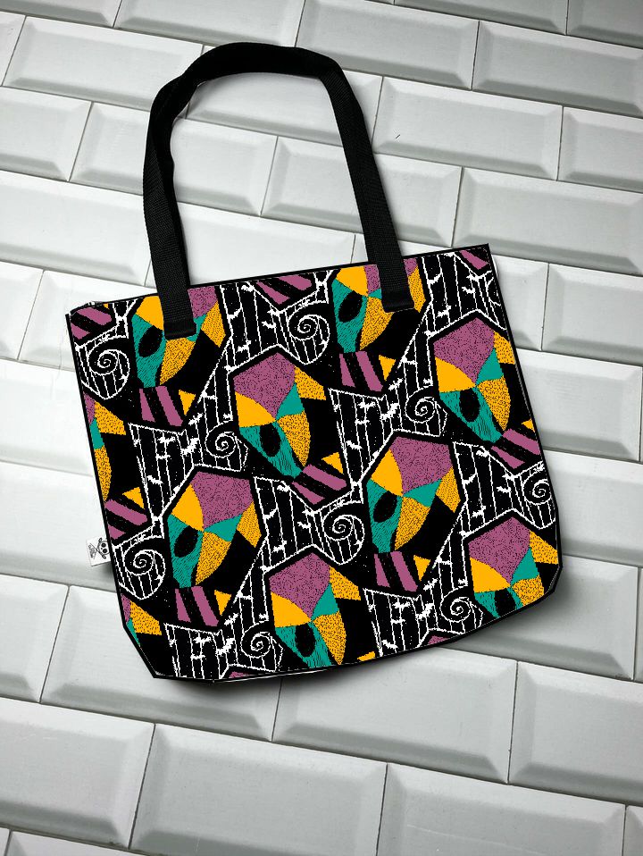 Saco de tecido colorido com padrão geométrico sobre fundo branco azulejado