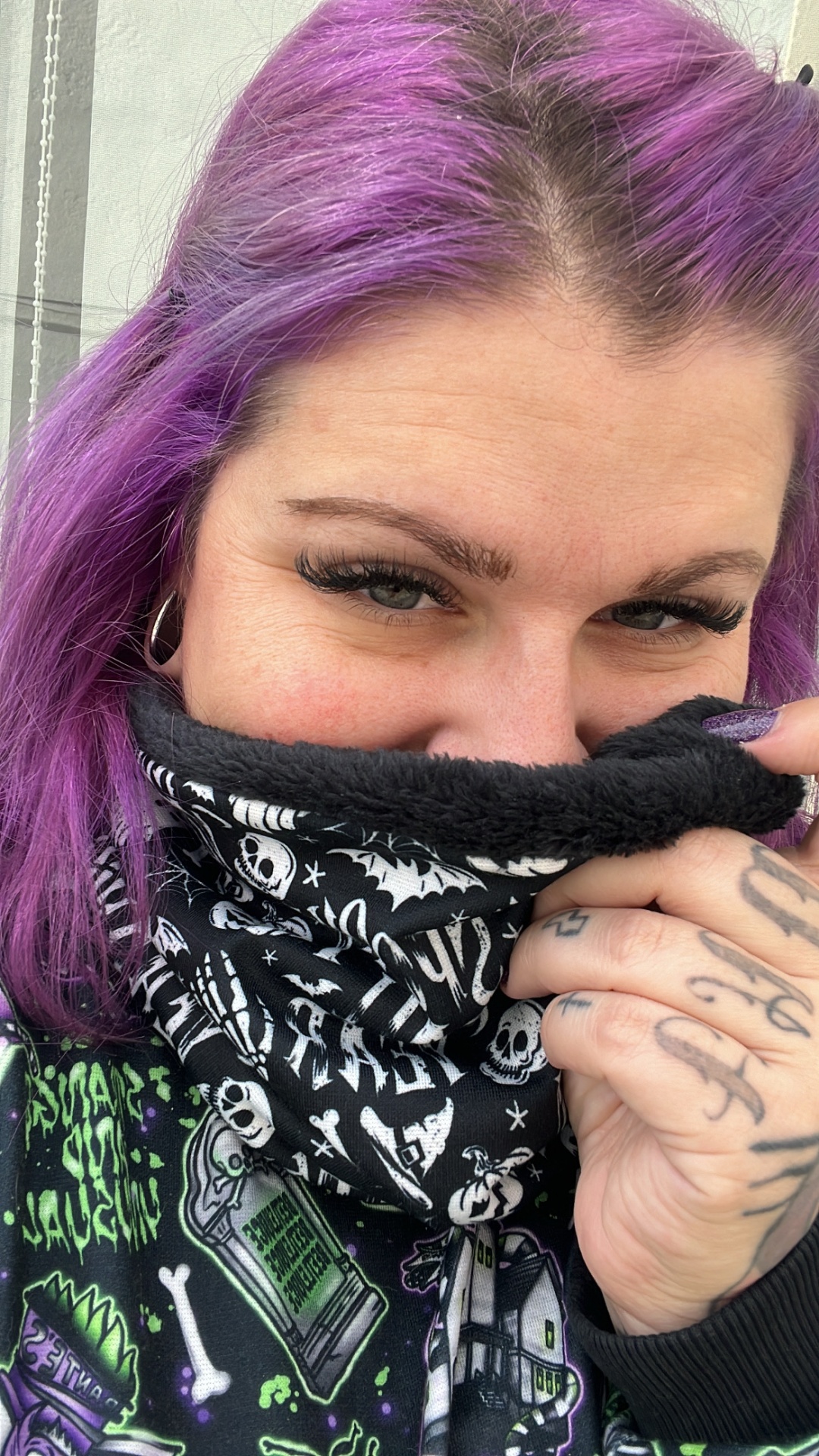 Pessoa com cachecol ou polaina preta forrada a pelúcia com estampado de caveiras e ossos