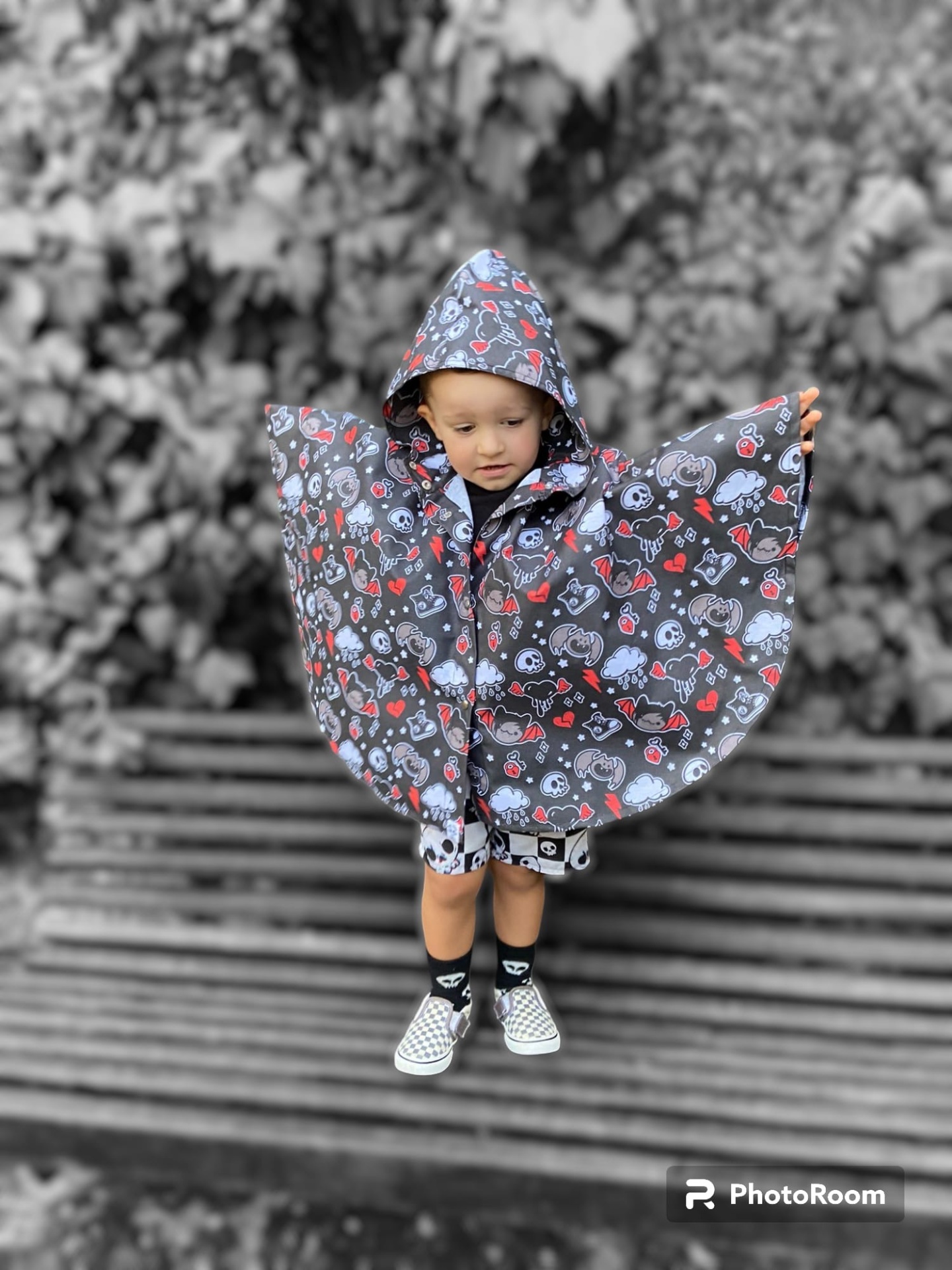 Capa de chuva infantil cinzenta com padrão colorido e capuz