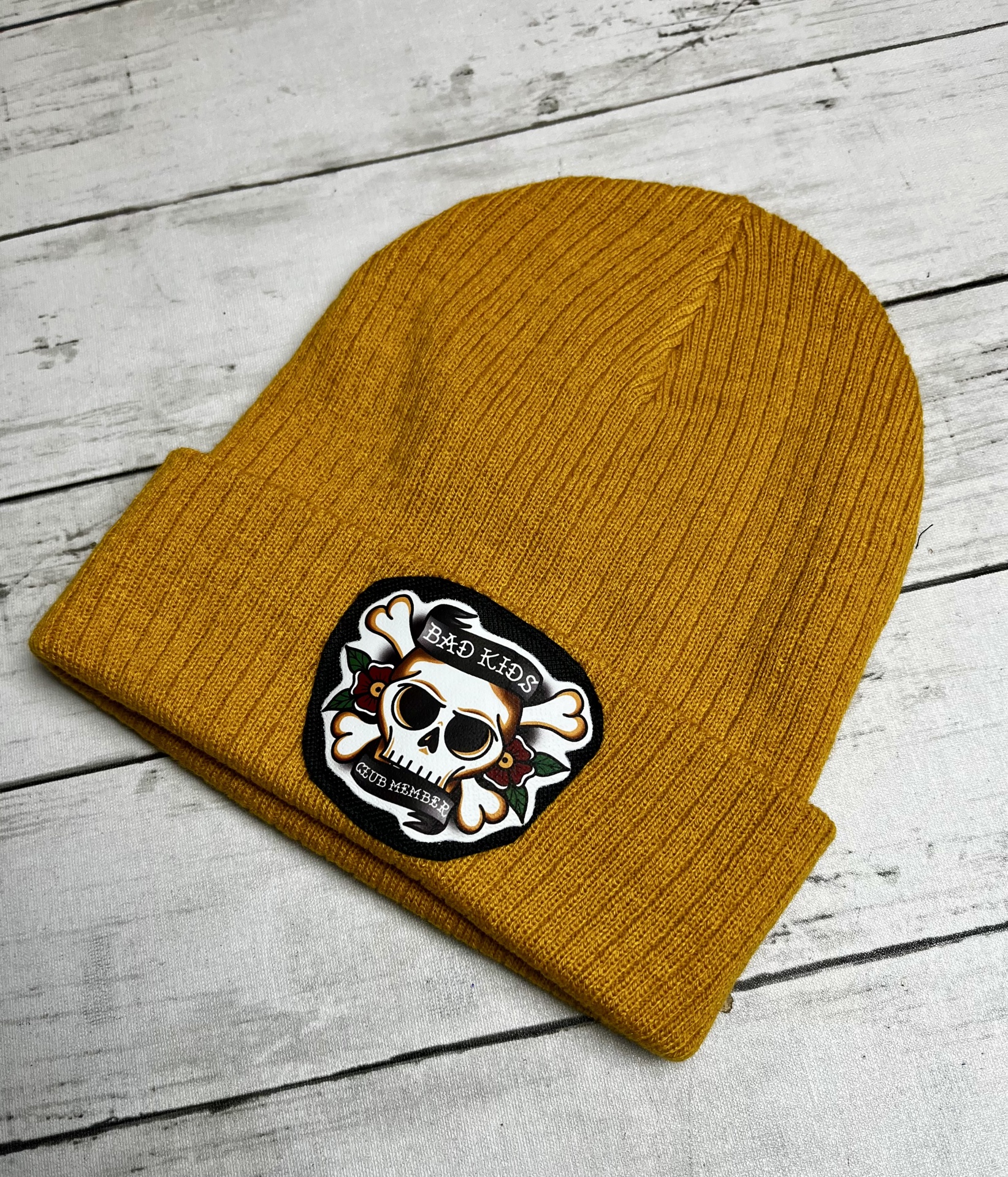 Gorro amarelo com patch de caveira e texto Bad Kids Club Member