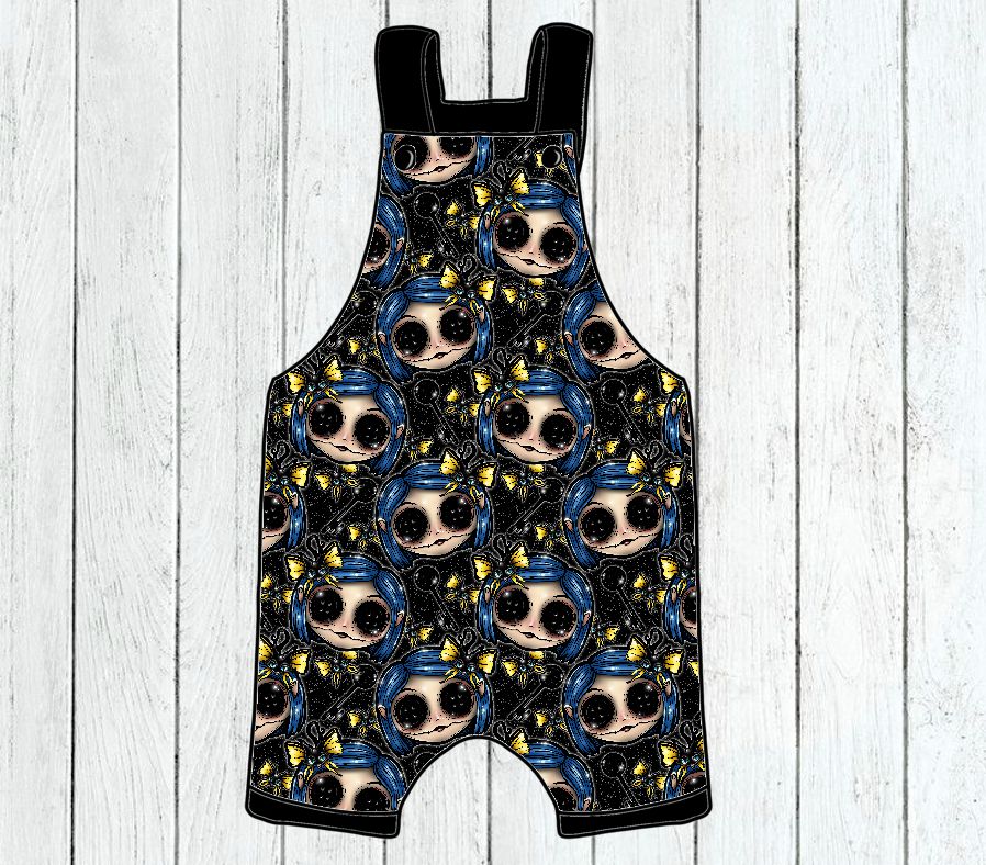 Jardineira para criança com padrão de rostos de bonecas em tecido