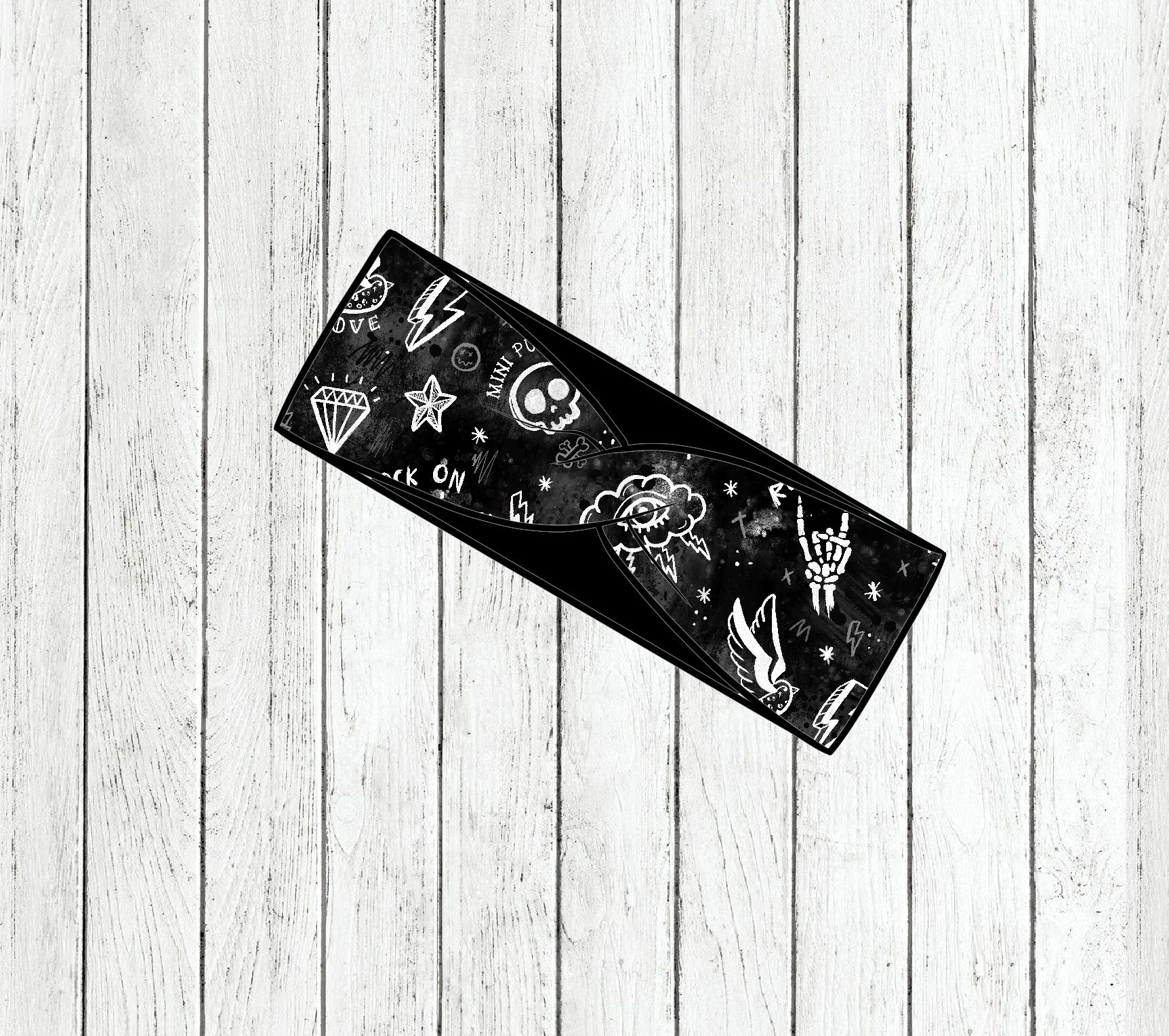 Faixa preta com desenhos brancos variados sobre tábua de madeira clara