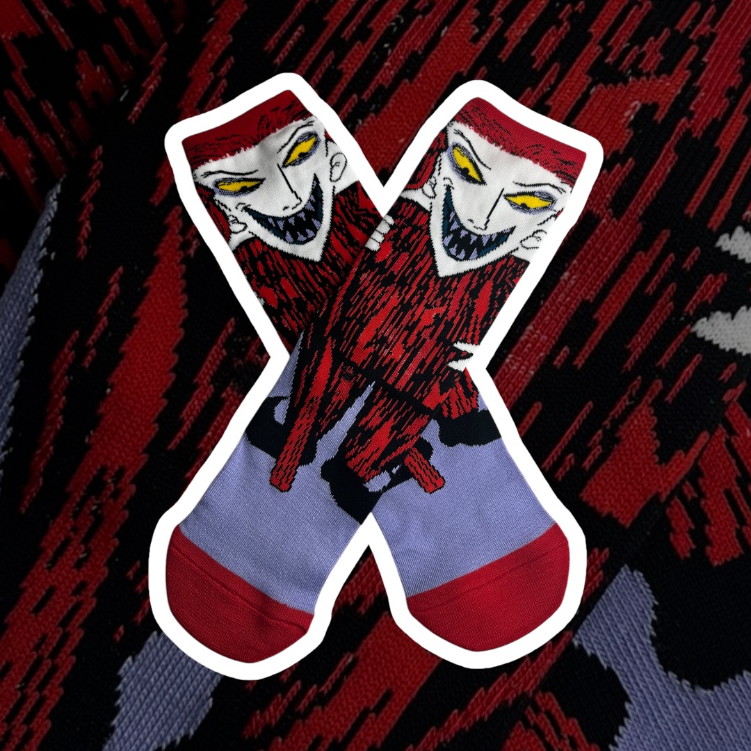 Meias com padrão gráfico e rosto de personagem sinistro em vermelho, preto e roxo