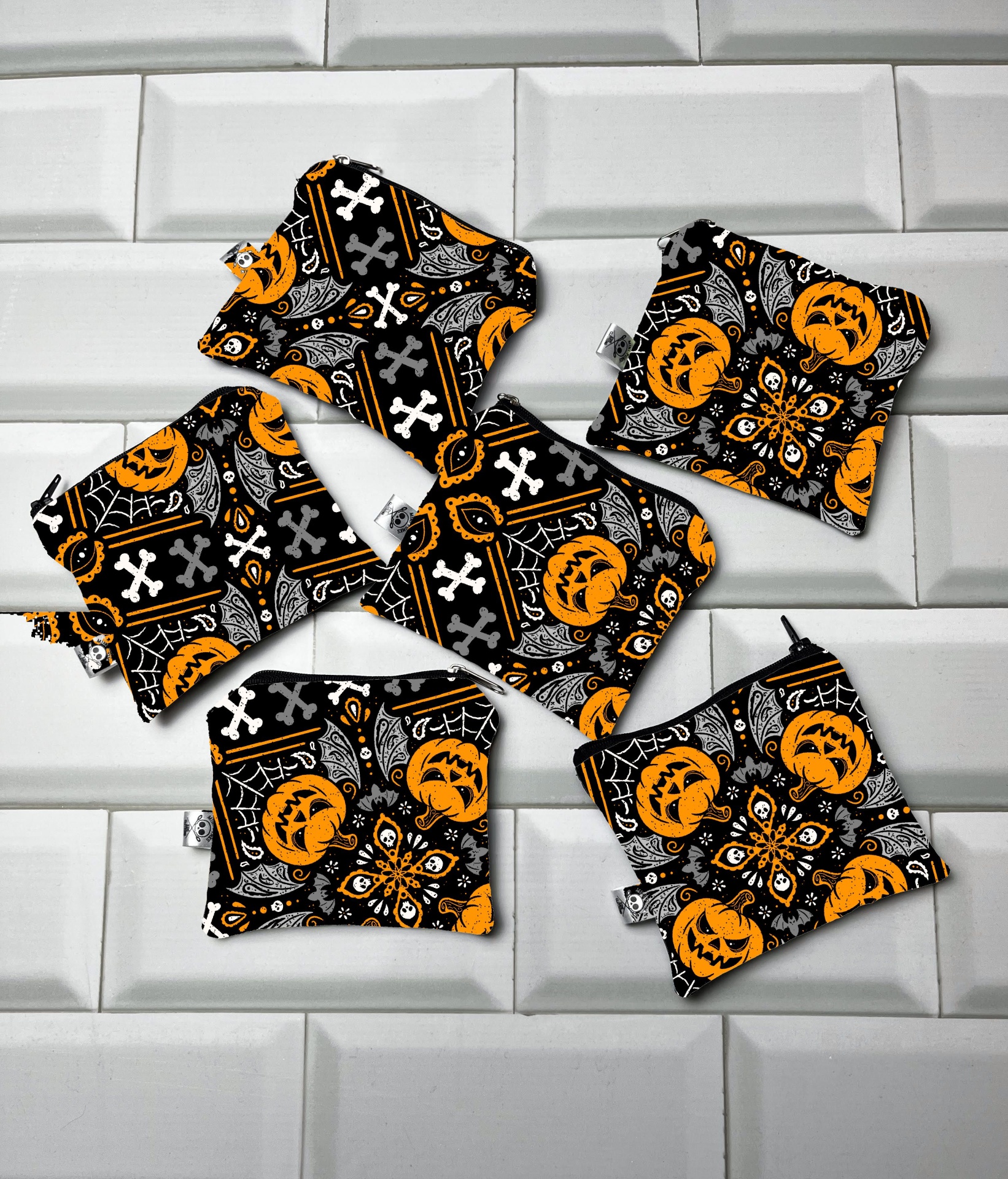 Acessórios de tecido Halloween preto, branco e laranja sobre azulejos brancos