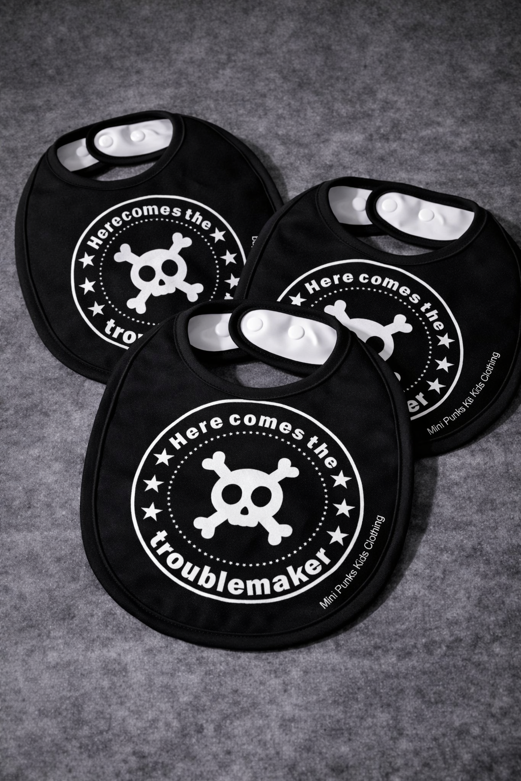 Babetes pretos para bebés com desenho de crânio e texto Here comes the troublemaker