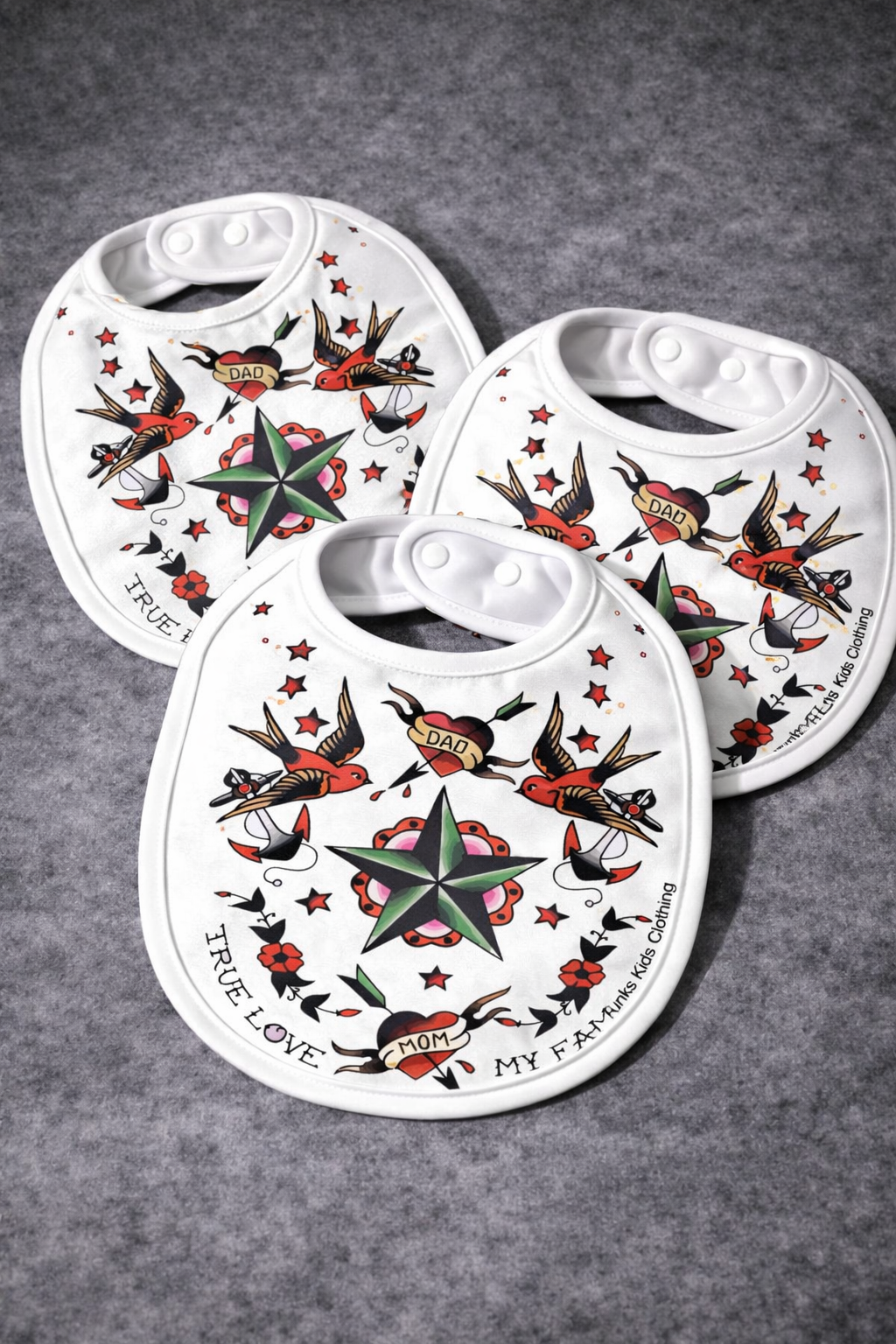 Três babetes brancos com design de tatuagem tradicional