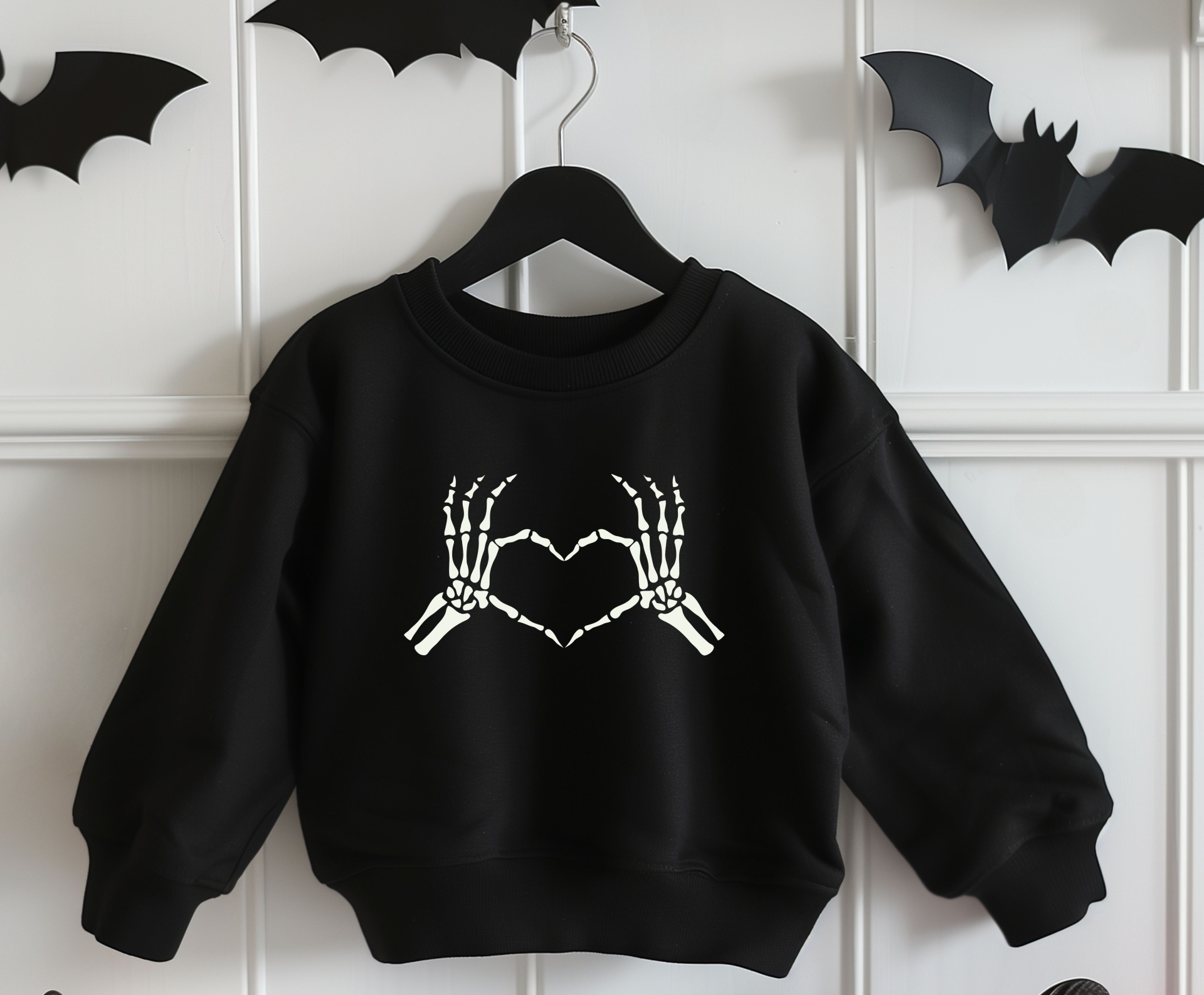 Sweatshirt preta com padrão de mãos esqueléticas brancas formando coração