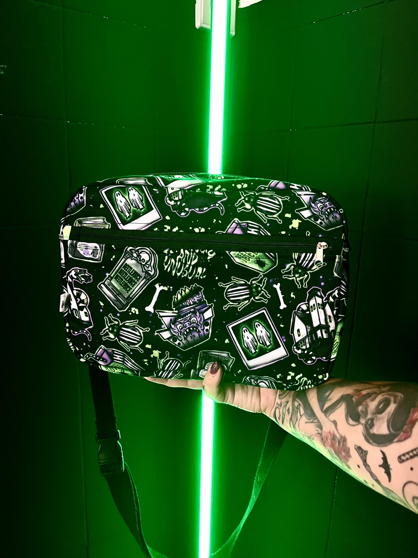 Mala pequena preta com padrão de desenhos de fantasmas, besouros e monstros