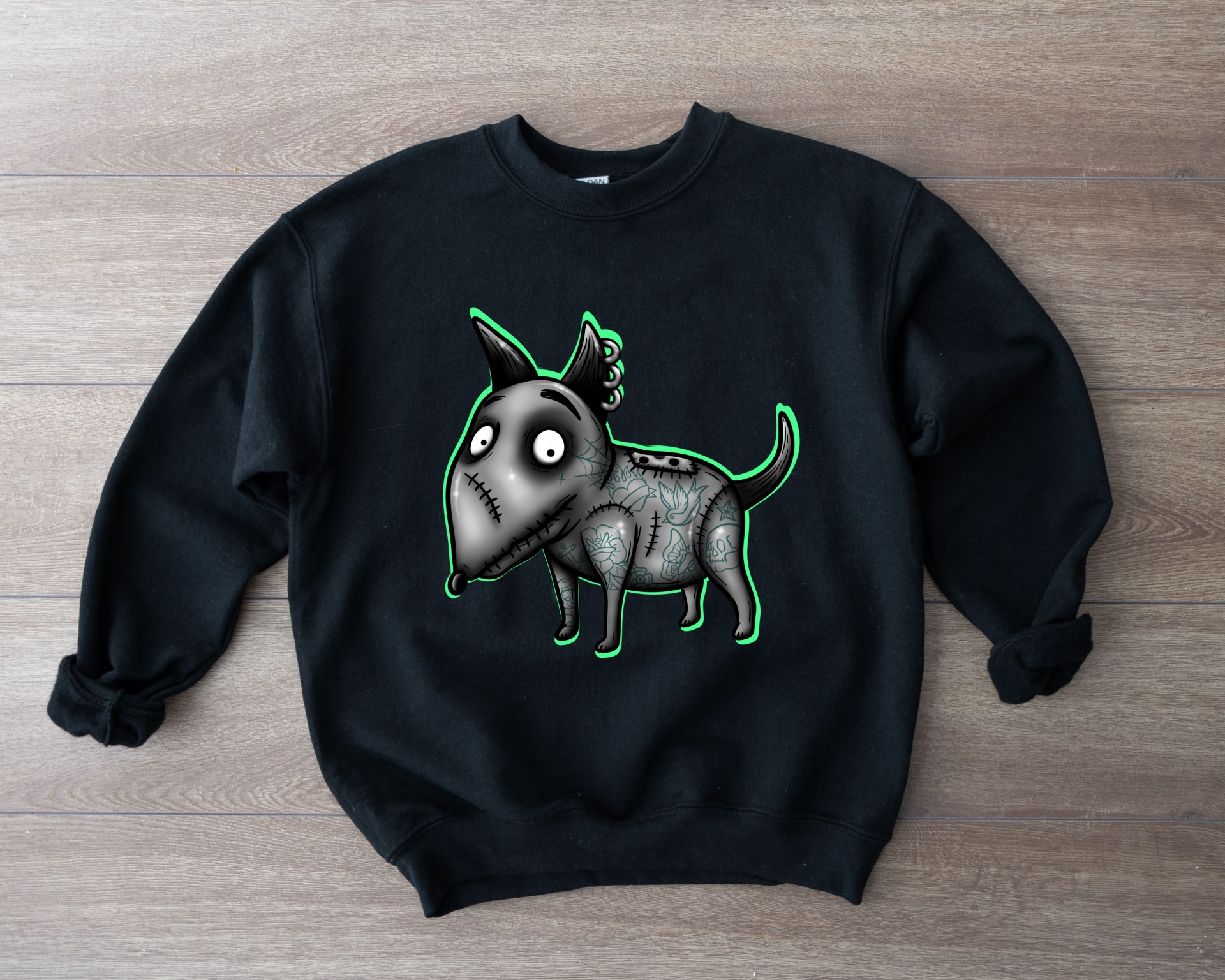 Sweatshirt preta com desenho de cão cinzento e verde sobre fundo de madeira